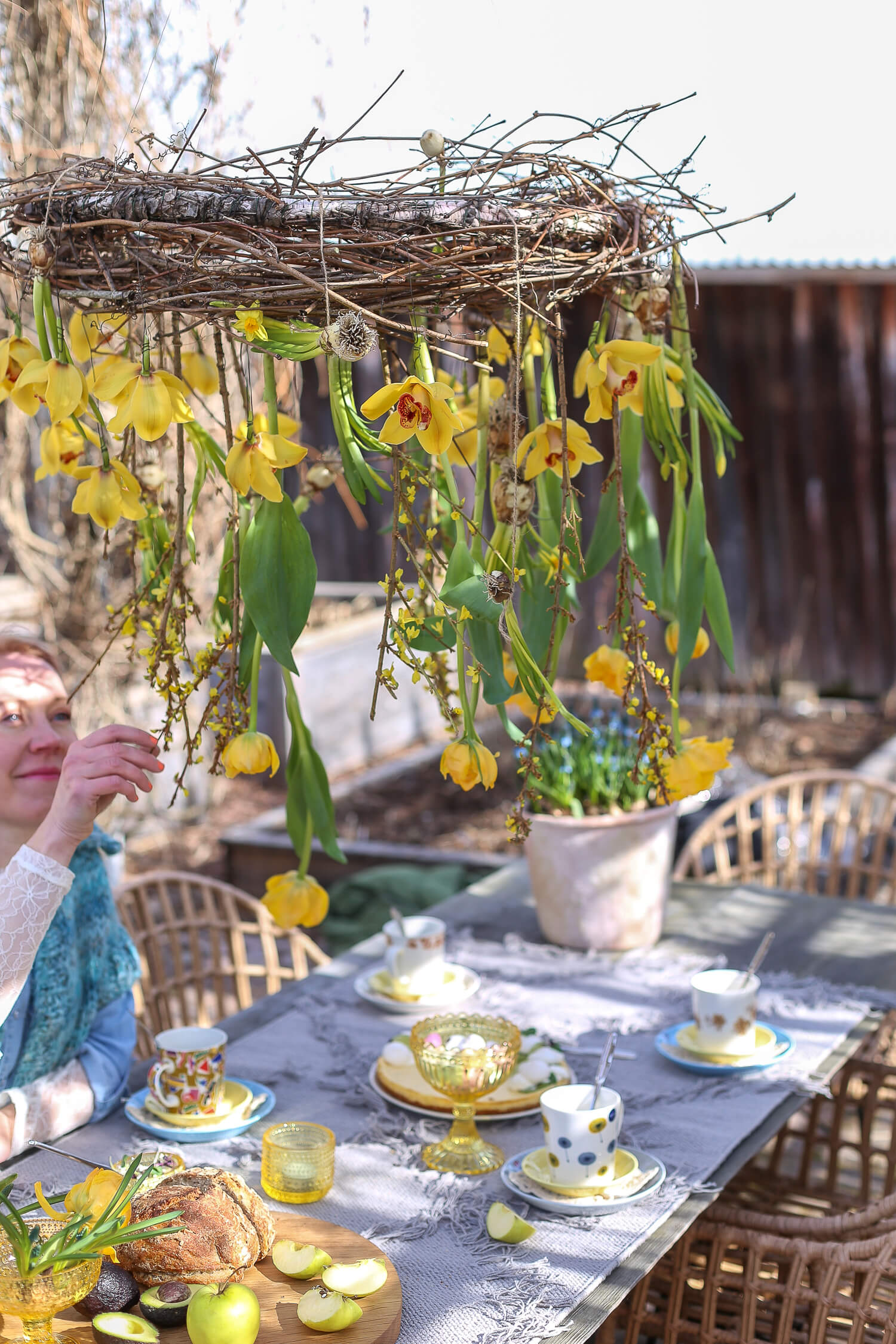 pääsiäiskahvit katetaan puutarhan pöydälle ja koristellaan roikkuvalla kukkakattokruunulla