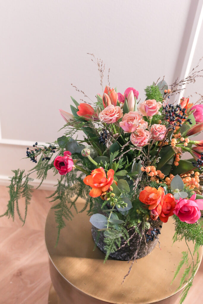 Värikäs rento ja ilmavasti sidottukimppu kultaisella pienellä pöydällä