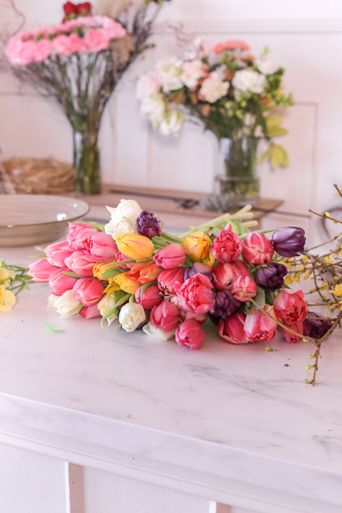 Värikkäitä tulppaaneja työtasolla pinkkejä,liloja,punaisia,keltaisia